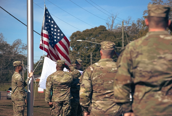 Service members saluting the flag.