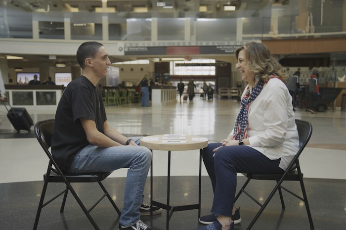 Two strangers (one civilian, one service member) meeting at Atlanta International Airport.