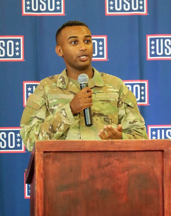 Sgt. Michael Wolkeba speaking in front of USO banner