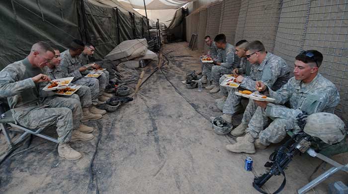Servicemen eating home-cooked meals during deployment.