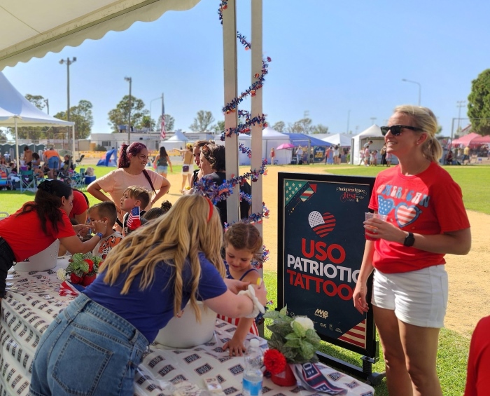 Adults and children at Fourth of July celebration with temporary tattoos at USO Rota in Spain