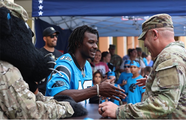 Carolina Panthers player shakes hands with service member at event at USO Grafenwoehr