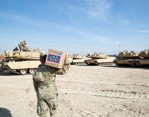 Service member carries USO care packages on base.