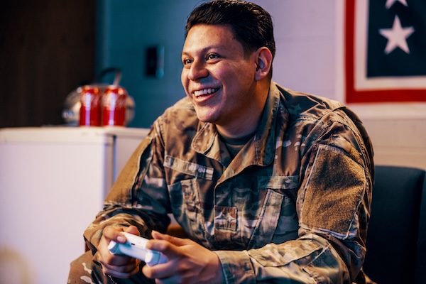 Service members playing video games and card games at USO Centers.