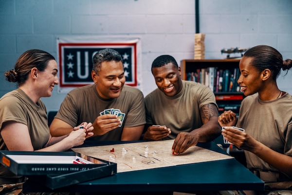 Service members playing video games and card games at USO Centers.