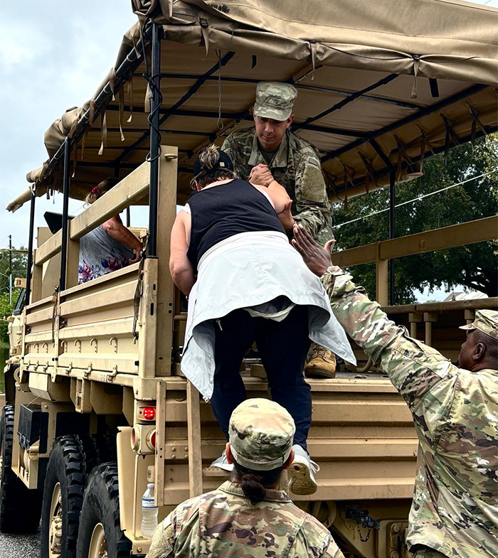 National Guard member helps civilian to safety in FL.