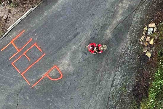 Word 'HELP' written on road where service members are responding.