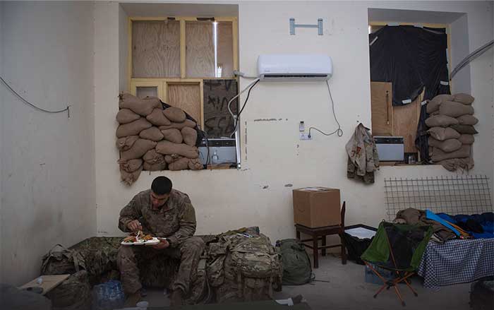 Service member eating a meal by himself overseas