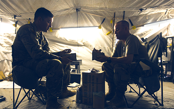 Two service members sit together.