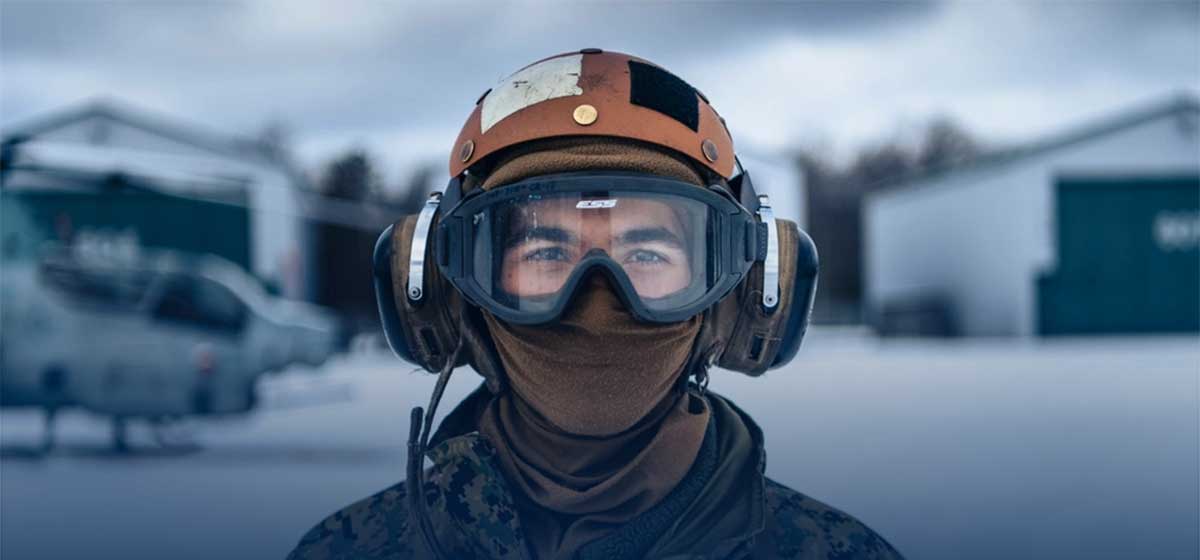 Service member salutes while looking into the camera.