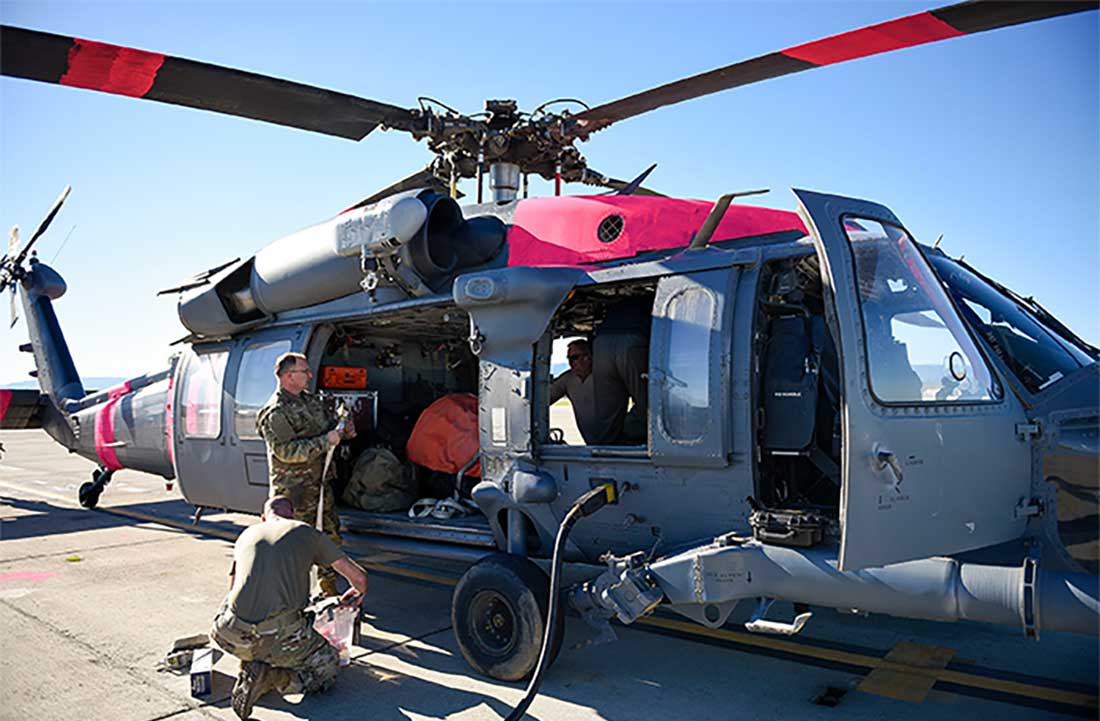 California National Guard load equipment and a Bambi bucket onto an HH-60G Pave Hawk helicopter to support the fire-fighting efforts in Los Angeles, California.