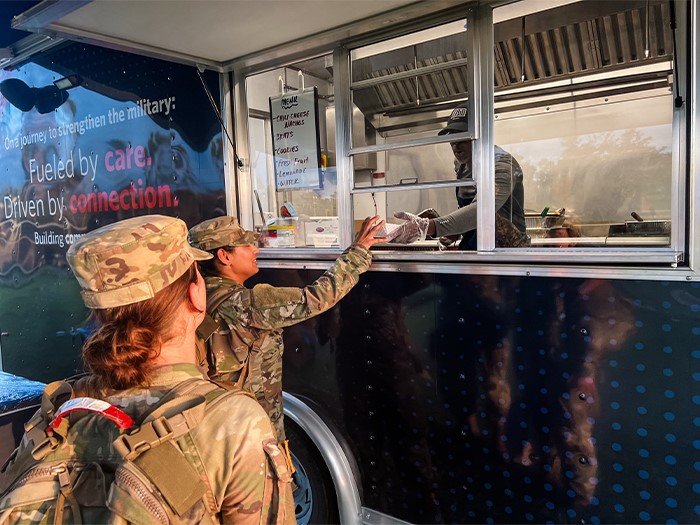 Two National Guard members receiving a warm meal at a Mobile USO.