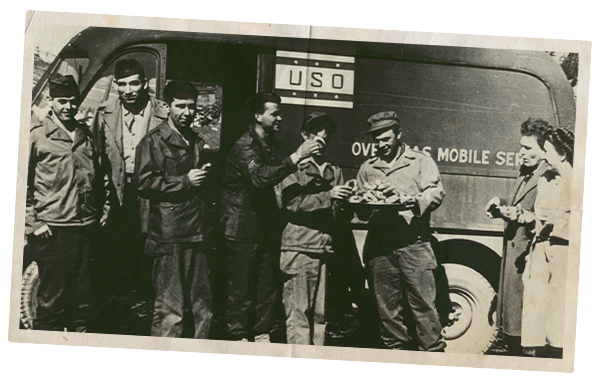 Old photograph of service members in front of USO truck