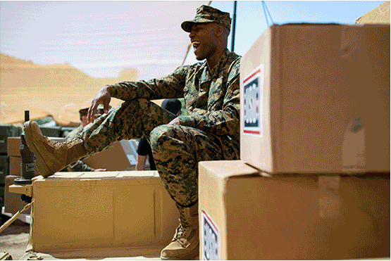 Service members unpacking USO packages; Service members enjoying hot dogs and grilling; Service member hugging son; Service member sitting on USO packages and smiling. 