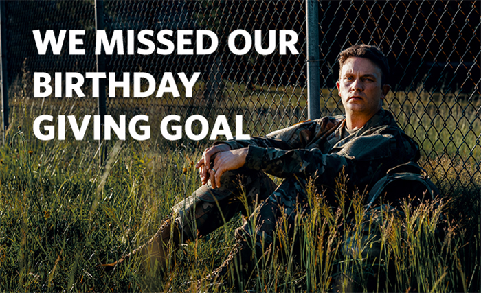 Soldier sitting alone in a field.