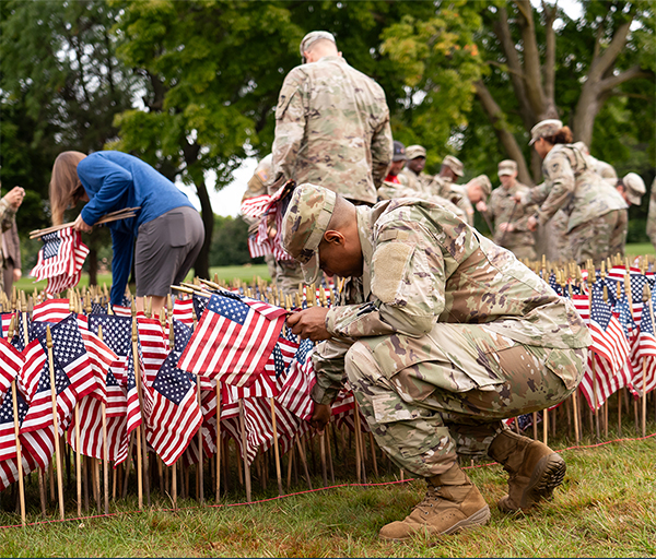 Service members placing flags in respect.