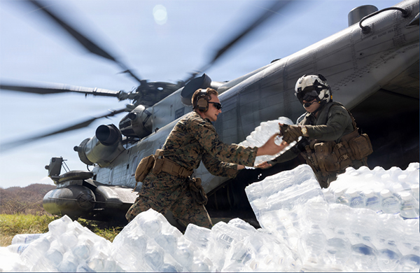 Service members unloading water from a helicopter Service members unloading water from a helicopter