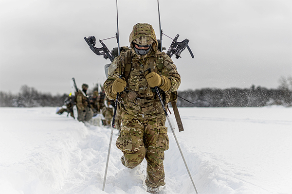 Service members moving through the snow.
