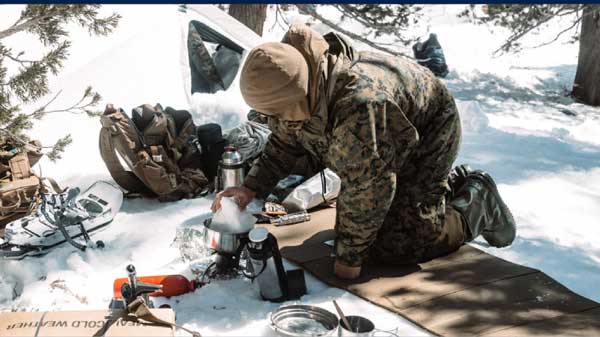 Service member eating in snow