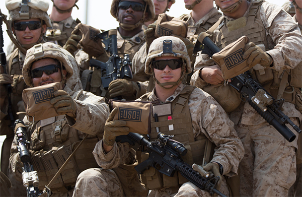 Service members holding USO care packages.
