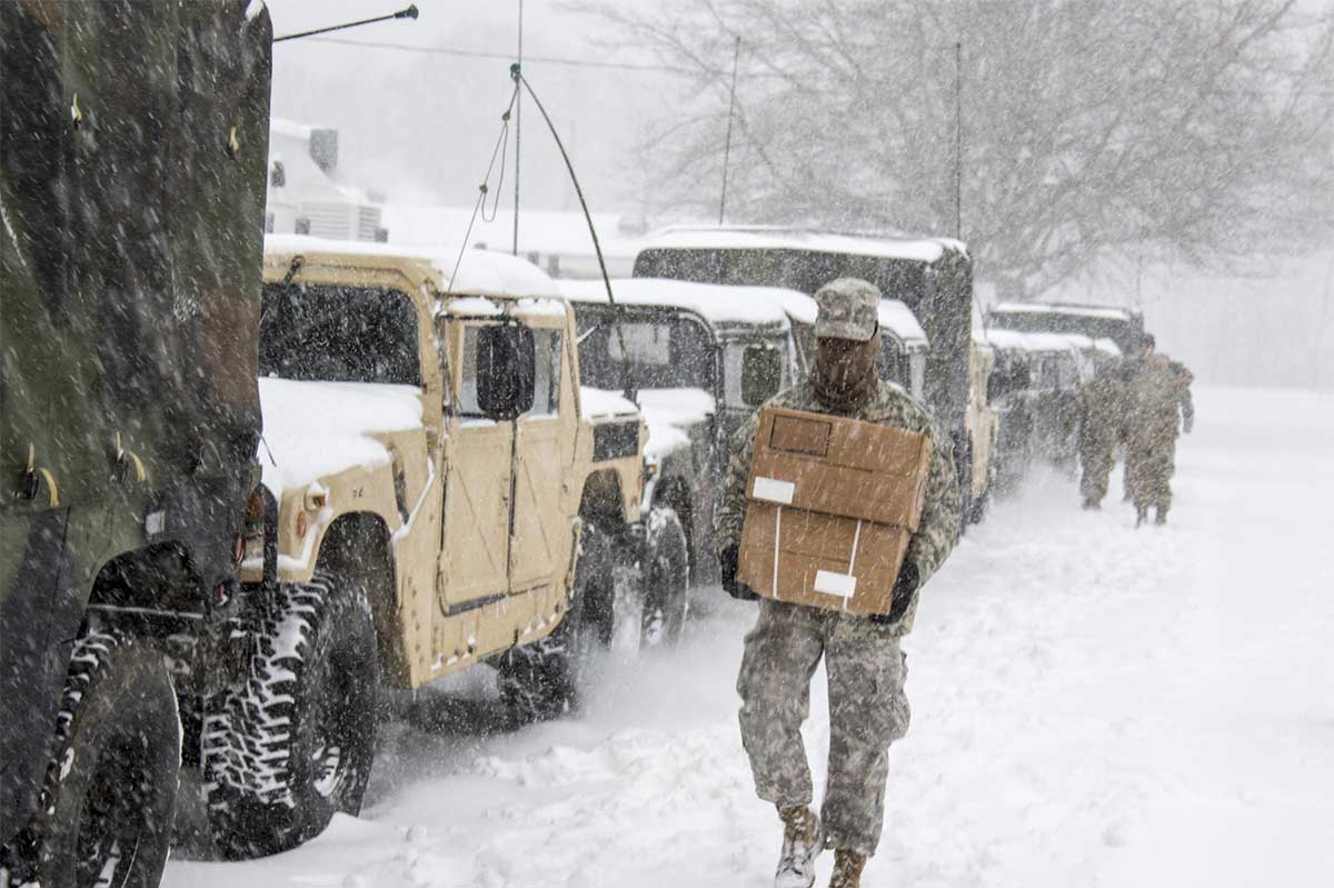 Service member walking through snow storm.