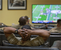Service members watching football together.